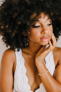 Styled boudoir photography with natural hair African American woman wearing handcrafted aquamarine earrings and sparkly bridal bracelet by J'Adorn Designs fine art jewelry
