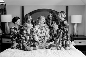 Smiling bridal party in robes, bride wears sparkly gold bridal teardrop earrings by J'Adorn Designs bridal jeweler for a classic Annapolis wedding at Chesapeake Bay Beach Club