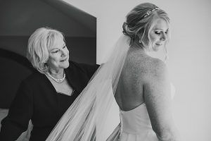 Smiling blonde bride with her mother, bride wears sparkly gold bridal teardrop earrings by J'Adorn Designs bridal jeweler for a classic Annapolis wedding at Chesapeake Bay Beach Club