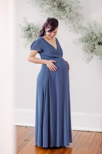 Maternity portrait of a mother-to-be wearing a slate grey gown and silver aquamarine jewelry to match. Handcrafted jewelry for a maternity photo session by J'Adorn Designs