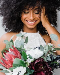 Natural and clean wedding style inspiration featuring an African American bride with curly hair, wearing a white jumpsuit and modern crystal spike bracelet by J'Adorn Designs handcrafted bridal bracelet